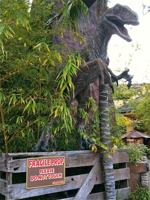T-rex animatronic prop at Universal Studios Hollywood with Fragile Do Not Touch sign -- brand story governance metaphor